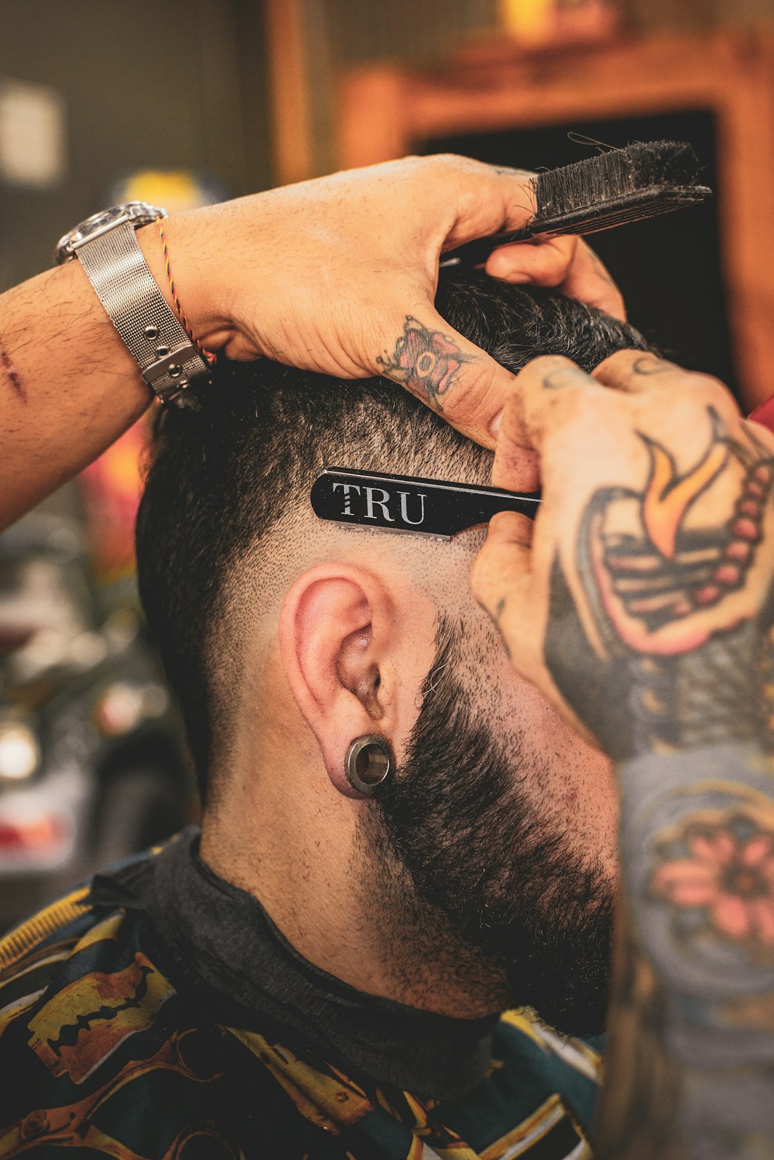 Barber carefully shaping a fresh cut, framed like an editorial poster