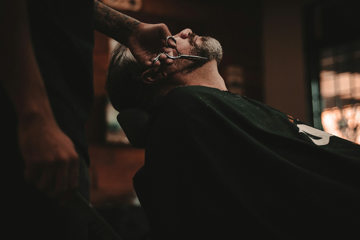 A barber refining a beard with traditional technique